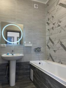 a bathroom with a sink and a tub and a mirror at ЖК Champion in Astana