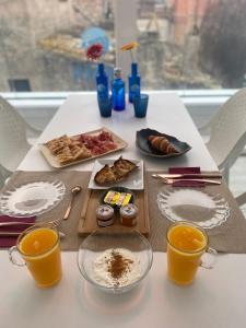 a table with food and two cups of orange juice at Mamma Mia Hotel Boutique - Only Adults in Tossa de Mar
