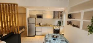 a kitchen with a stainless steel refrigerator and a table at Depto de alquiler San Juan in San Juan