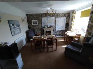 a dining room with a table and chairs and a fireplace at Chyheira in Ruan Minor