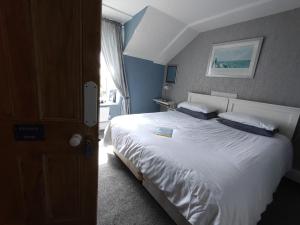 a bedroom with a large white bed with blue walls at Chyheira in Ruan Minor