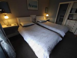 two twin beds in a bedroom with two lamps at Chyheira in Ruan Minor