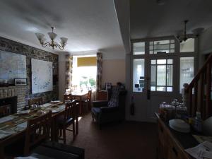 a dining room with a table and chairs and a room with a table at Chyheira in Ruan Minor
