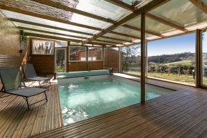 a swimming pool in a house with a deck at Rural Cottage in Alfeizerão