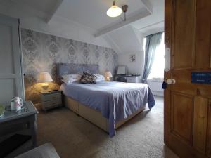 a bedroom with a bed and two lamps and a window at Chyheira in Ruan Minor