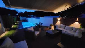 ein Wohnzimmer mit einem Sofa und einem Pool in der Nacht in der Unterkunft Casa do Pai Beach House in Aldeia do Meco