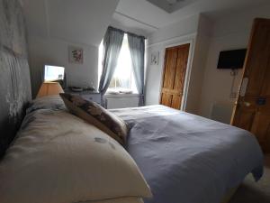 a bedroom with a large white bed with a window at Chyheira in Ruan Minor