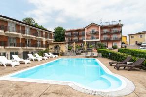 einen Pool mit Stühlen und ein Gebäude in der Unterkunft Boutique Hotel Grahor in Sežana