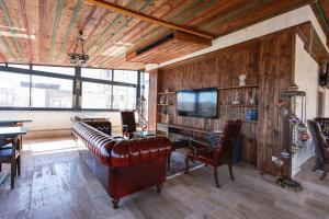 a living room with a leather couch and a television at Garden Suites Hotel Cappadocia in Göreme