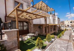 - une terrasse avec une table et des chaises dans un bâtiment dans l'établissement Garden Suites Hotel Cappadocia, à Gorëme