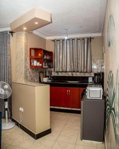 een keuken met rode kasten en een aanrecht bij Modern Furnished Rooms with Netflix, Kitchen, Living room , Laundry DStv and Free WiFi in Kampala