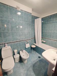 a bathroom with a toilet and a bidet and a sink at Pertinho do Rio in Ponte de Lima