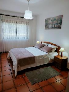 een slaapkamer met een groot bed en een raam bij Pertinho do Rio in Ponte de Lima
