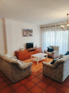 Una sala de estar con dos sofás y una mesa. en Pertinho do Rio, en Ponte de Lima