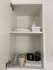 a cupboard filled with dishes and other kitchen items at Soba Milojkovic in Golubac