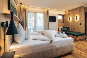 a bedroom with a large white bed in a room at Familienhotel Post in Serfaus +50 photos