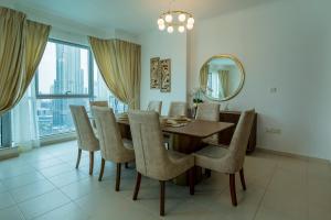 a dining room with a table and chairs and a mirror at INA Homes-Residences Tower 7 Full Burj Khalifa & Fountain Views in Dubai