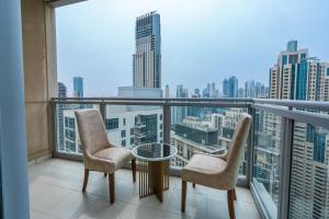 a balcony with two chairs and a table and a view at INA Homes-Residences Tower 7 Full Burj Khalifa & Fountain Views in Dubai