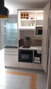 una cucina con frigorifero a pianta aperta e forno a microonde di L hibiscus a Saint-François