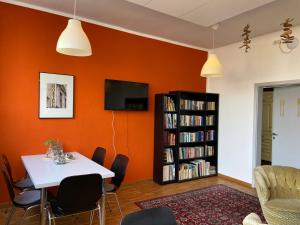 a dining room with a table and a book shelf at Hostel Stralsund in Stralsund