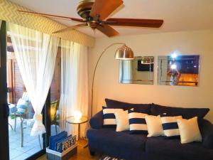 a living room with a couch and a ceiling fan at Luxury Beachfront King Suite on Sapphire Beach II in East End