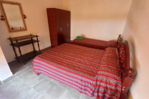 a bed with a striped blanket in a bedroom at Miskysisa in Humahuaca