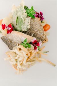 a sandwich with flowers on a white plate at Hotel Grahor Depandance in Sežana +13 photos
