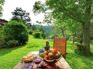 una mesa con un bol de fruta y una botella de vino en Farmhouse in Cortona wit garden and pool, en Cortona