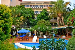 un hotel con piscina y sillas y un edificio en Hotel Arthur Shambala, en Encarnación