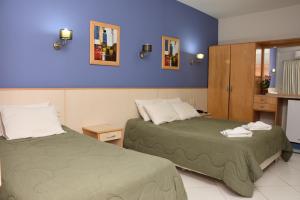 duas camas num quarto com paredes roxas em Hotel Arthur Shambala em Encarnación