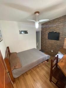 1 dormitorio con 1 cama y ventilador de techo en Suítes dos anjos!, en Arraial do Cabo