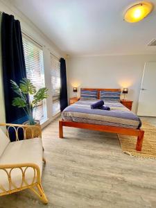 Beach front 4 x2 Home with pool في جيرالدتون: غرفة نوم مع سرير مزدوج كبير وأريكة
