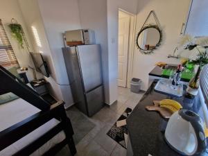 a kitchen with a sink and a refrigerator at Casa-Pel Tiny House in Palatswe