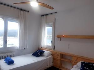zwei Betten in einem Zimmer mit zwei Fenstern in der Unterkunft Tramuntana, casa amb bones vistes a mar, T in Port de la Selva