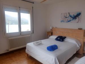 ein Schlafzimmer mit einem Bett mit zwei blauen Kissen darauf in der Unterkunft Tramuntana, casa amb bones vistes a mar, T in Port de la Selva