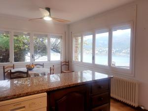 eine Küche mit einem Tisch und Fenster mit Aussicht in der Unterkunft Tramuntana, casa amb bones vistes a mar, T in Port de la Selva + 8 Fotos