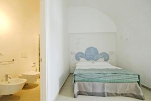 a bedroom with a bed and a sink and a toilet at Corte Scarcia in Ugento