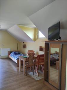 - un salon avec un lit et une table avec une télévision dans l'établissement Pokoje Noclegowe - Agroturystyka, à Brzostek