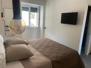 een slaapkamer met een bed en een flatscreen-tv bij Tresino Rooms in Agropoli