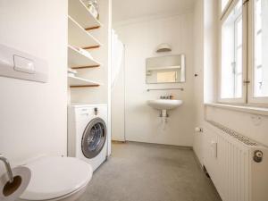 a white bathroom with a washing machine and a sink at WHITE DOUPLEX CHARM: big flat in the city centre in Copenhagen