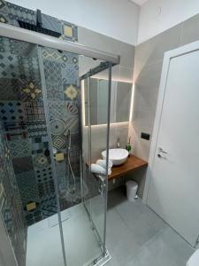 un bagno con doccia in vetro e lavandino di Tresino Rooms ad Agropoli Altre 36 foto