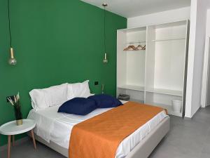 een slaapkamer met een bed met een groene muur bij Tresino Rooms in Agropoli