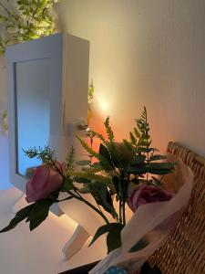 a vase of flowers on a table with a mirror at The Old Rectory in Jarrow