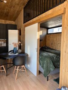 1 dormitorio con 1 cama y 1 mesa en una habitación en Attraktiv & smart funkishytte på Nes Strandhager., en Årnes