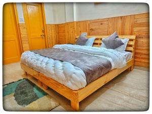 een slaapkamer met een groot houten bed met kussens bij Kullu Manali Homestay in Kulu