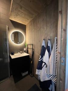 a bathroom with a sink and a mirror and towels at Attraktiv & smart funkishytte på Nes Strandhager. in Årnes