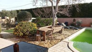 une arrière-cour avec une table de pique-nique et une piscine dans l'établissement Villa climatisée avec piscine, à Courthézon