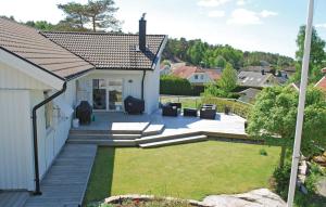 un patio trasero con terraza y césped en Amazing Home In Vstra Frlunda With Kitchen, en Västra Frölunda