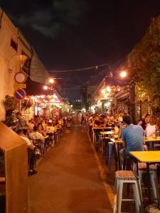 a crowd of people sitting at tables in a restaurant at night at A new Jaffa gallery apartment a minute from the beach and entertainment centers in Tel Aviv