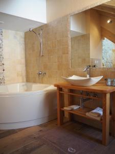 ein Badezimmer mit einer Badewanne, einem Waschbecken und einem Spiegel in der Unterkunft Aiguille de La Tza in Arolla